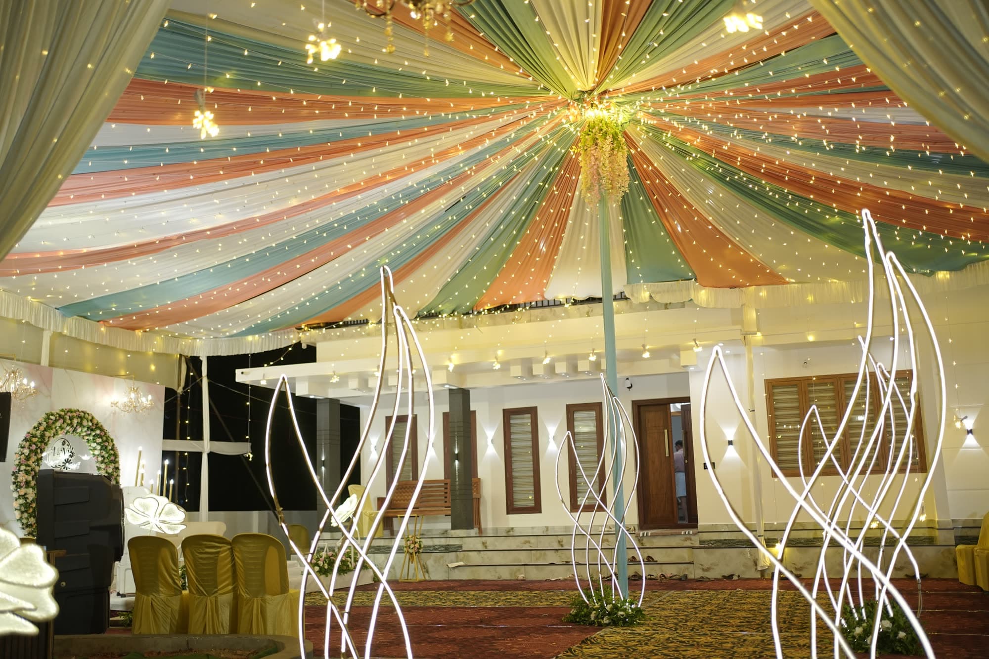 Striped fabric canopy overhead with warm fairy lights and a chandelier