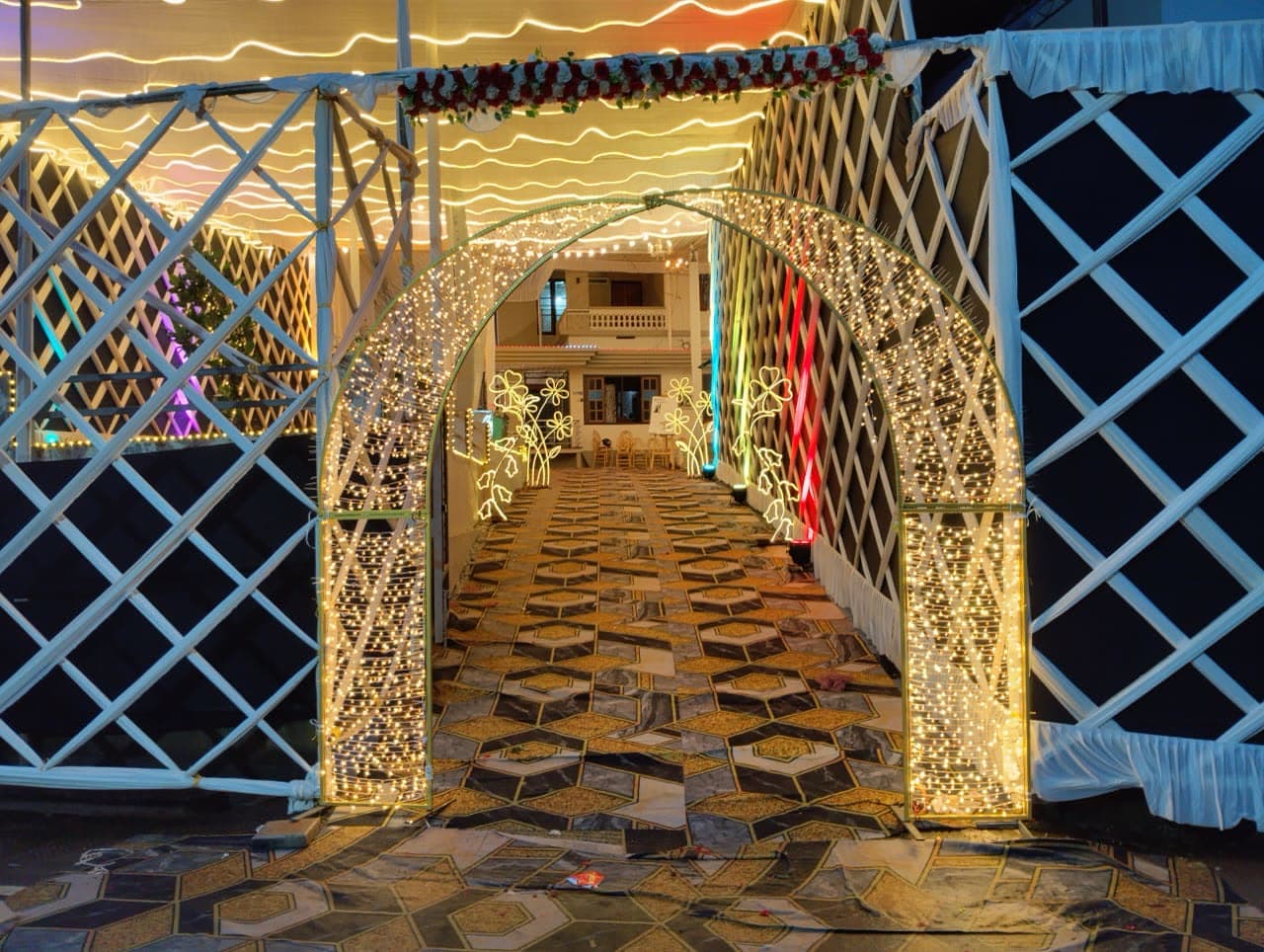 Tented arch with lattice panels and floral arrangements